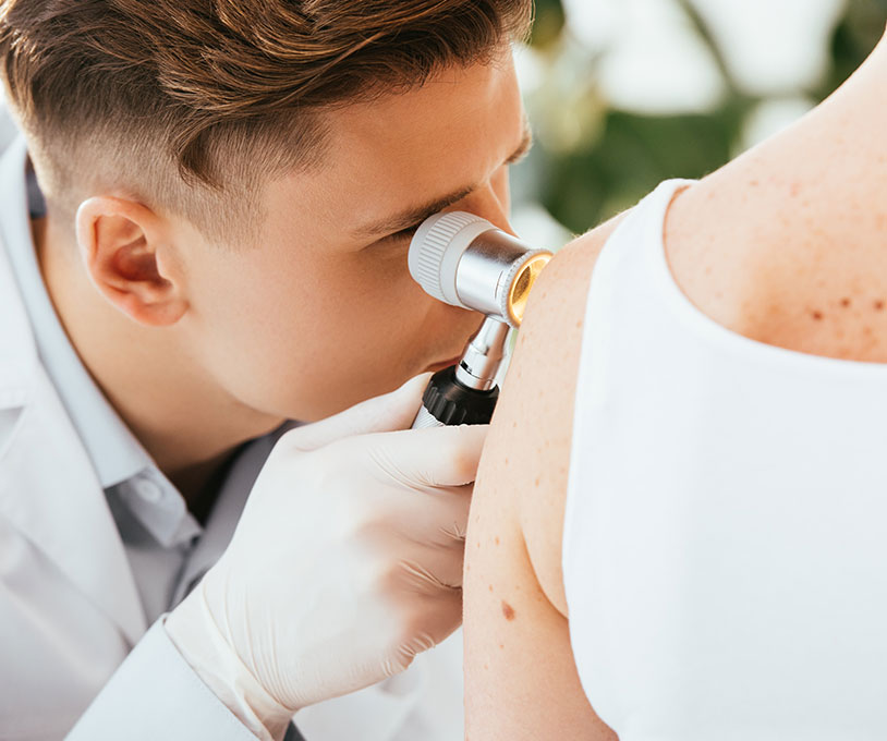 Dermatologist examining a patient using a dermatascope