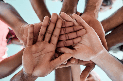 Hands of various races together representing patient diversity in dermatology clinical trials