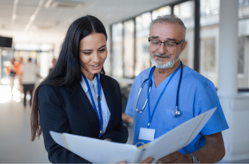 female and male clinicians look at file, representing why investigators need study coordinators